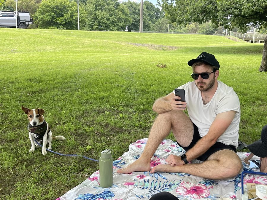 Jye sitting on a picnic blanket in a park
